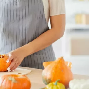 Woman scooping out pumpkin to cook to get their health benefits