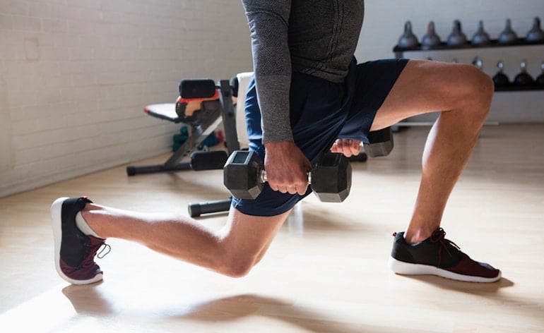 Man doing lunges with weights as part of his butt lifting workout