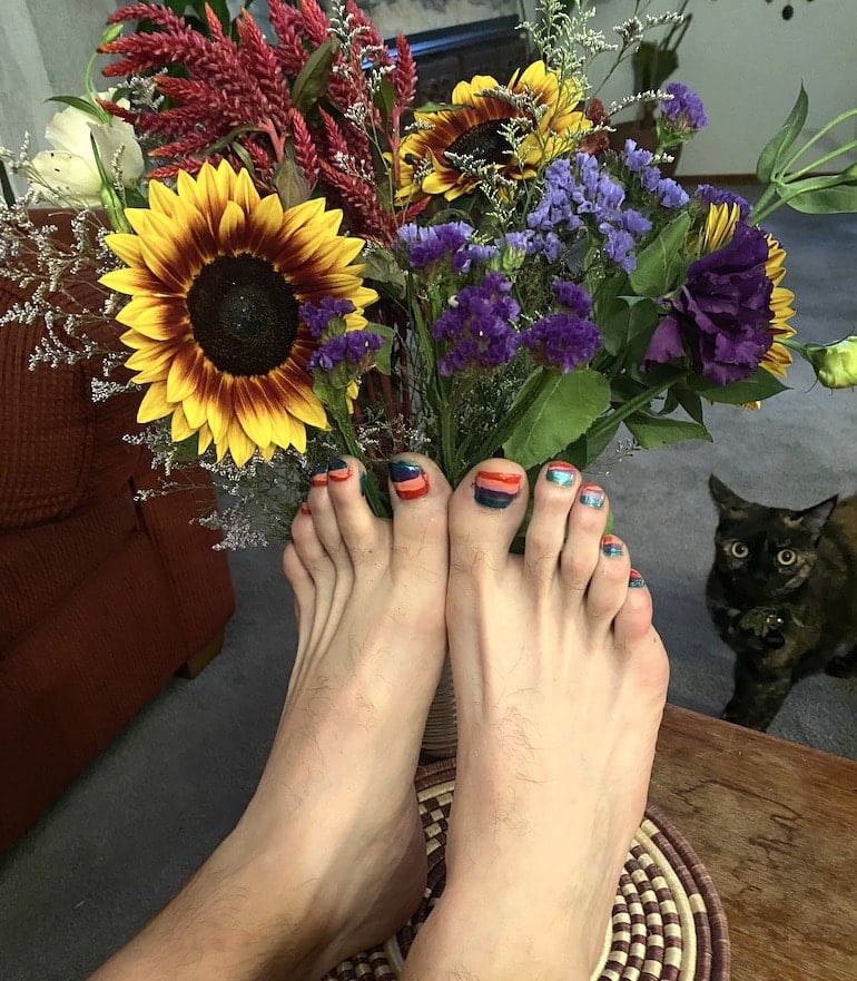 Man with colorful gel pedicure to illustrate that guys can wear nail polish