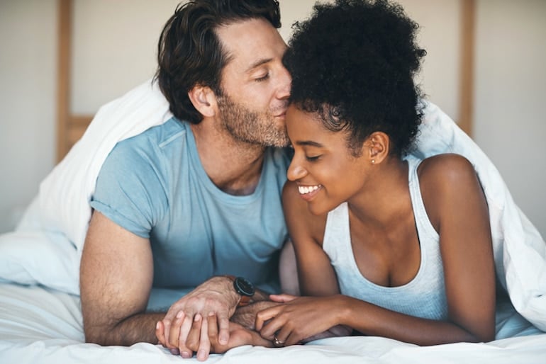 Man kissing wife in bed to illustrate healthy sperm and male fertility concepts