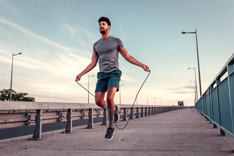 Man jumping rope outdoors to get in cardio to lose weight