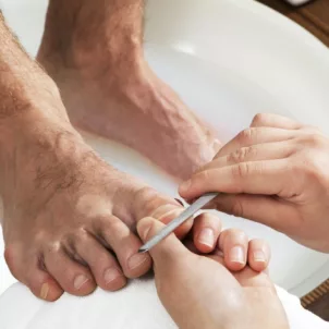 Man getting a pedicure, showing that men wearing nail polish is normal