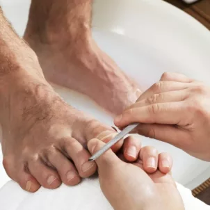 Man getting a pedicure, showing that men wearing nail polish is normal