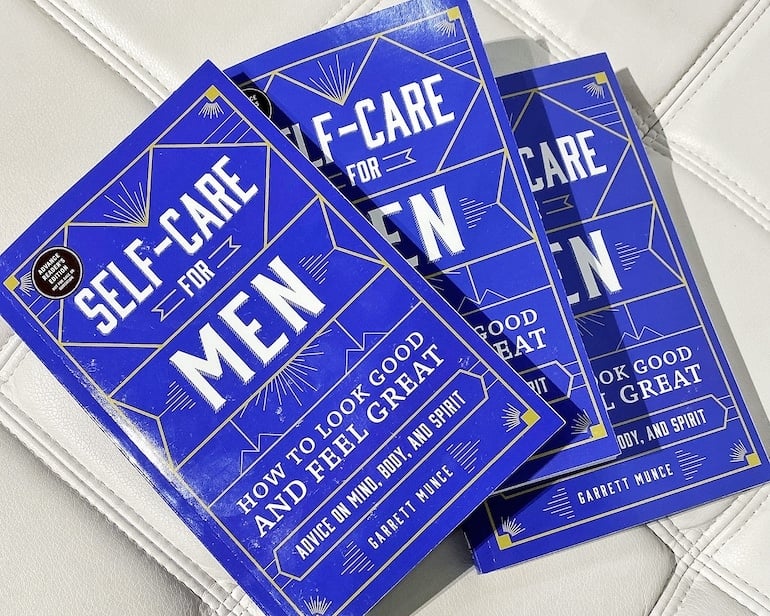 Copies of the book Self-Care for Men by Garrett Munce 