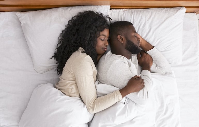 Couple sleeping to illustrate what sleep does for the brain