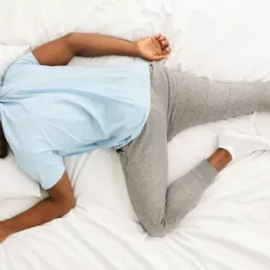 Overhead shot of man sleeping on his stomach to intro article on what your sleeping position says about you