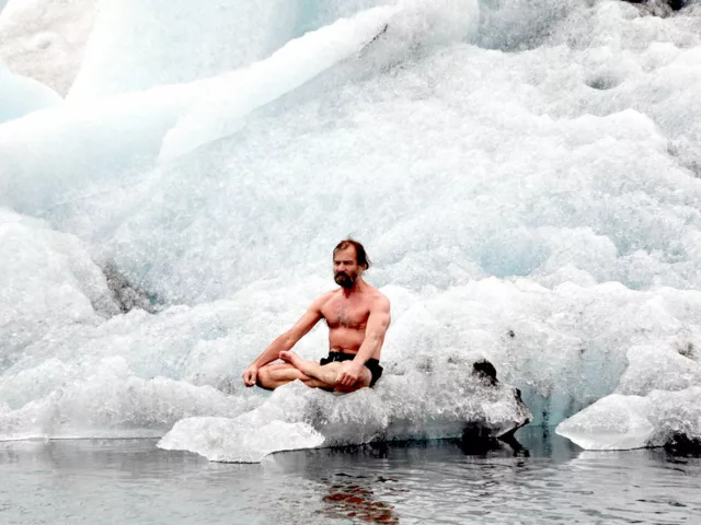 The Iceman Wim Hof sitting on a block of ice, practicing the Wim Hof Method of cold therapy and breathwork