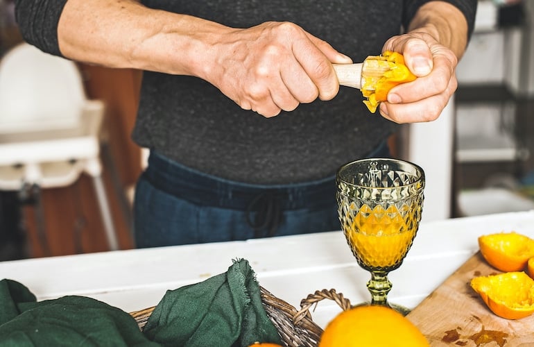 Man juicing oranges, since it's one of the best foods to eat for healthy sperm