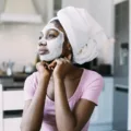 Woman sitting at kitchen table with a DIY hydrating face mask on to save her dry skin in the winter