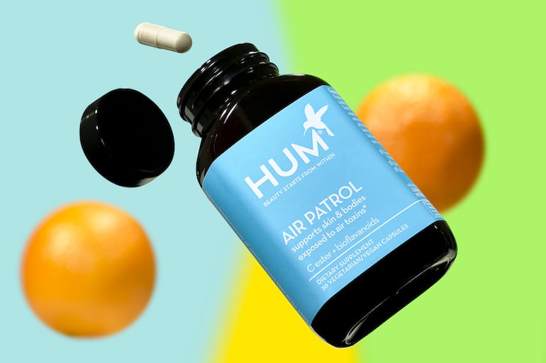 HUM Air Patrol vitamin C supplement for immunity next to oranges on colorful background