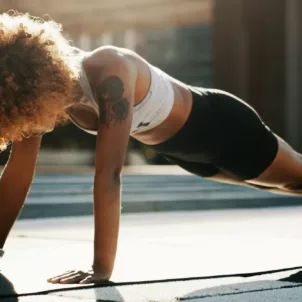 Woman in plank position exercising outdoors to boost her immune system