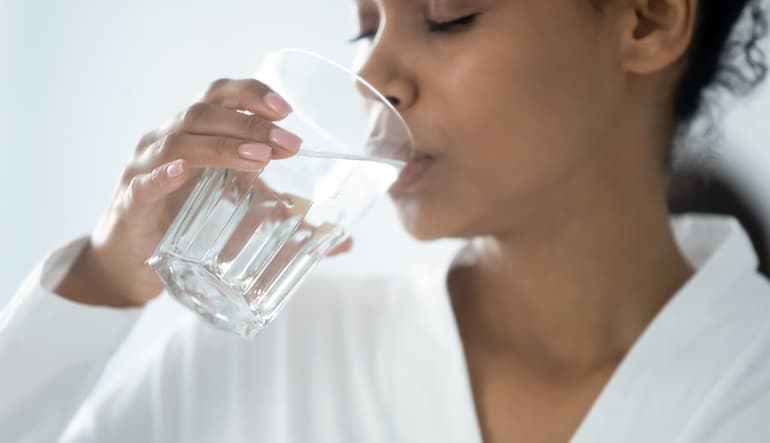 Woman drinking water in the hopes to reduce farting and smelly farts