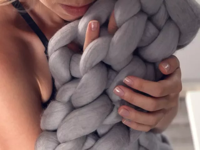 Woman holding a Bearaby cotton napper to review and see if weighted blankets are worth it