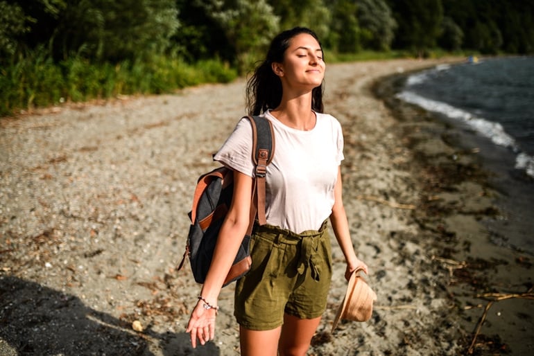 Calm and relaxed woman breathing in fresh air and enjoying the benefits of spending time in nature