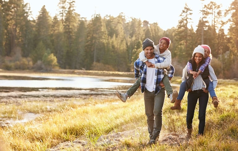 Family of four walking in nature to experience the calming health benefits