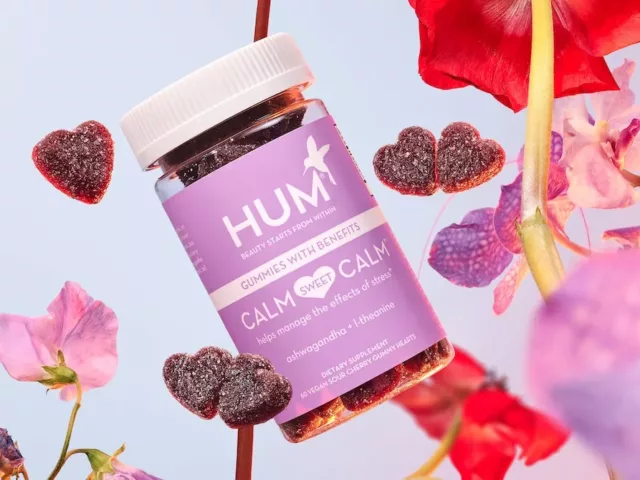 HUM Calm Sweet Calm stress gummies with flowers in front of a lilac background