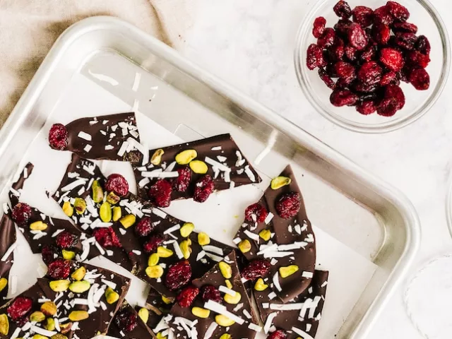 Dark Chocolate Bark Recipe ingredients, including cranberry and coconut, on countertop