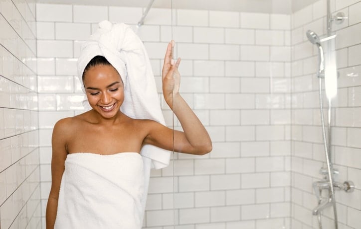 Woman coming out to shower to illustrate healthy vaginal hygiene concept to prevent itching and smelly discharge