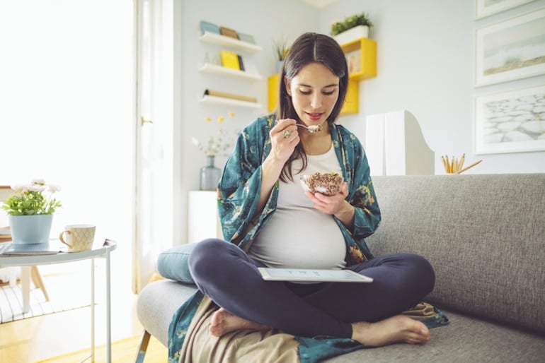 Pregnant woman eating breakfast to meet her prenatal nutrition needs