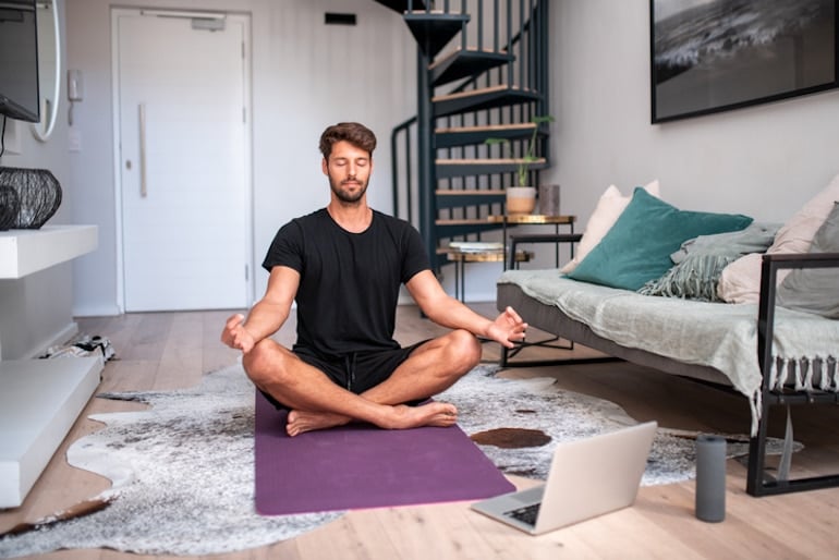 Man meditating and doing breathwork at home, a key skill to learn on how to be present