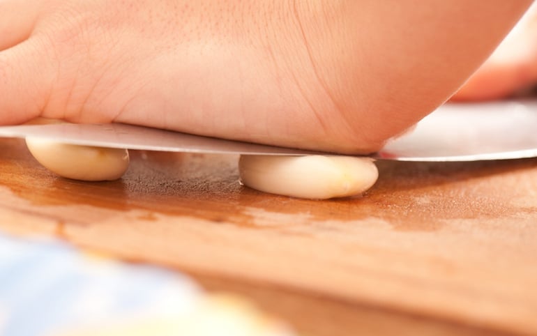 Man crushing garlic cloves to help increase libido naturally