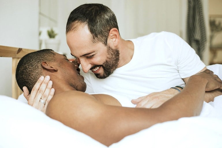 Gay couple in bed to suggest sex frequency in relationships