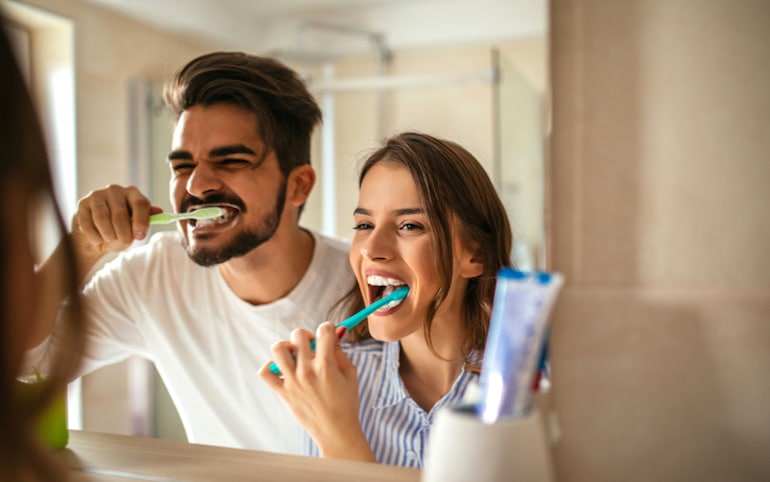 Couple brushing teeth together - an example of how unconscious habits can be beneficial