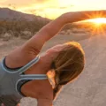 Woman stretching at sunset, with working out as her goal to form badass habits