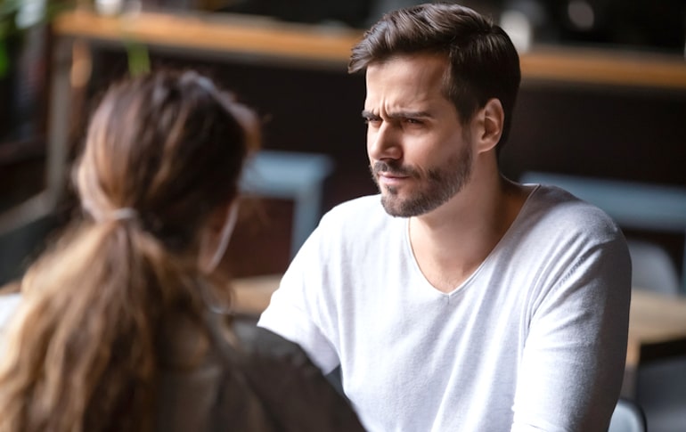 Man looking at friend with suspicion, not talking things out or respecting their feelings