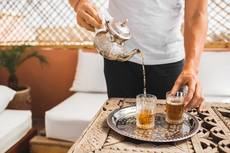 Man pouring Moroccan tea to help meet his hydration quota for the day