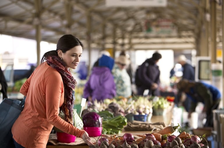 Woman buying fresh seasonal produce at farmers market