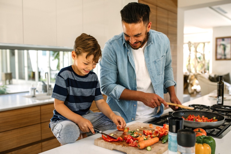 Father and son preparing veggies for a healthy meal