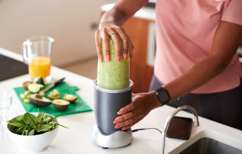 Closeup of female dietitian blending protein shake on workout day