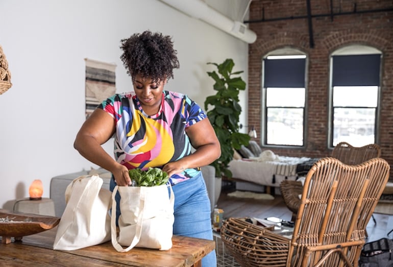 Woman unpacking her grocery bags with Flexitarian Diet staples like veggies and plant-based protein