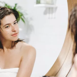 Woman spraying rice water into her hair to help it grow, according to the viral DIY hair trend