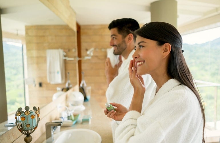 Couple doing their morning skincare routine in the bathroom, which includes the best niacinamide products for skin