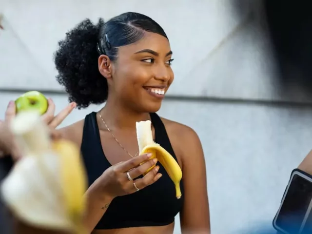 Woman eating a banana as a post workout food
