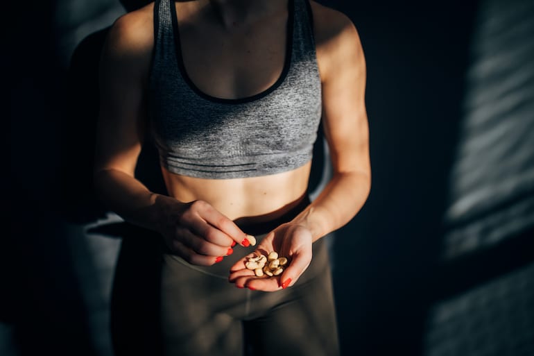 Woman eating nuts for healthy post workout food