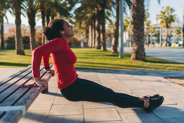 Woman strength training to build muscle in the park