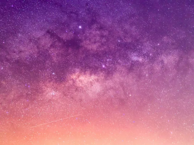 Purple, orange, and pink starry sky for astrology concept and April 2021 wellness horoscopes