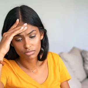 Woman on couch feeling fatigued and with a low libido, which may help her know if she has a hormonal imbalance