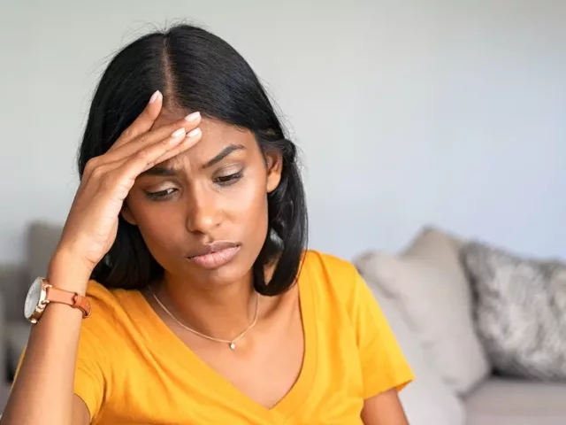 Woman on couch feeling fatigued and with a low libido, which may help her know if she has a hormonal imbalance