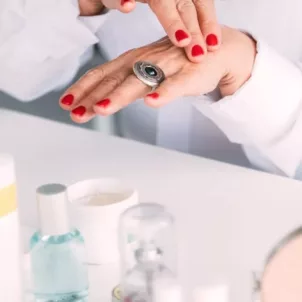 Woman at vanity thinking about how to recycle empty beauty products the right way