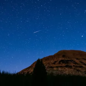Starry night sky in a mountain desert landscape; astrology and wellness horoscopes concept