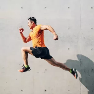 Sporty man jumping in the air to illustrate the best vitamins for energy