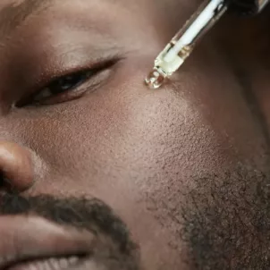 Man applying vitamin C serum to benefit his skin