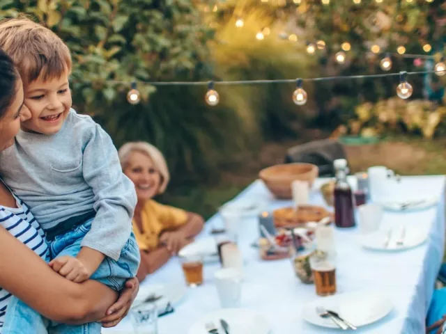 Multigenerational family eating dinner outside to illustrate how your nutritional needs change over time and by age group