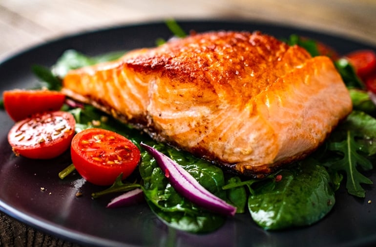 Meal with salmon and spinach, two of the best foods for hair growth and thickness