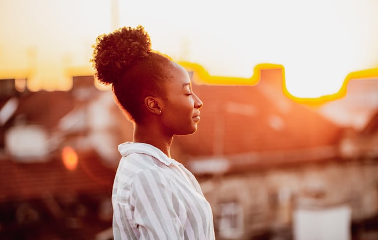 Calm woman with eyes closed outdoors; mental health concept