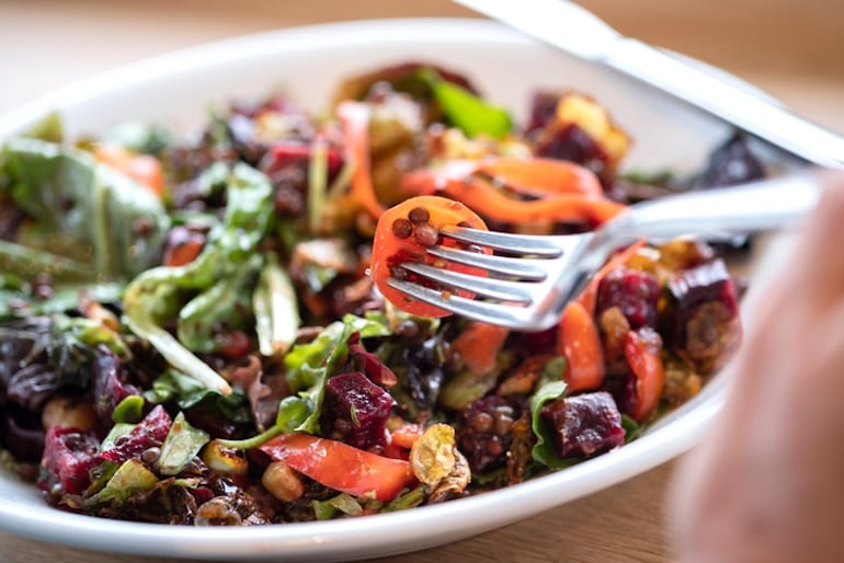 Person eating salad with lentils